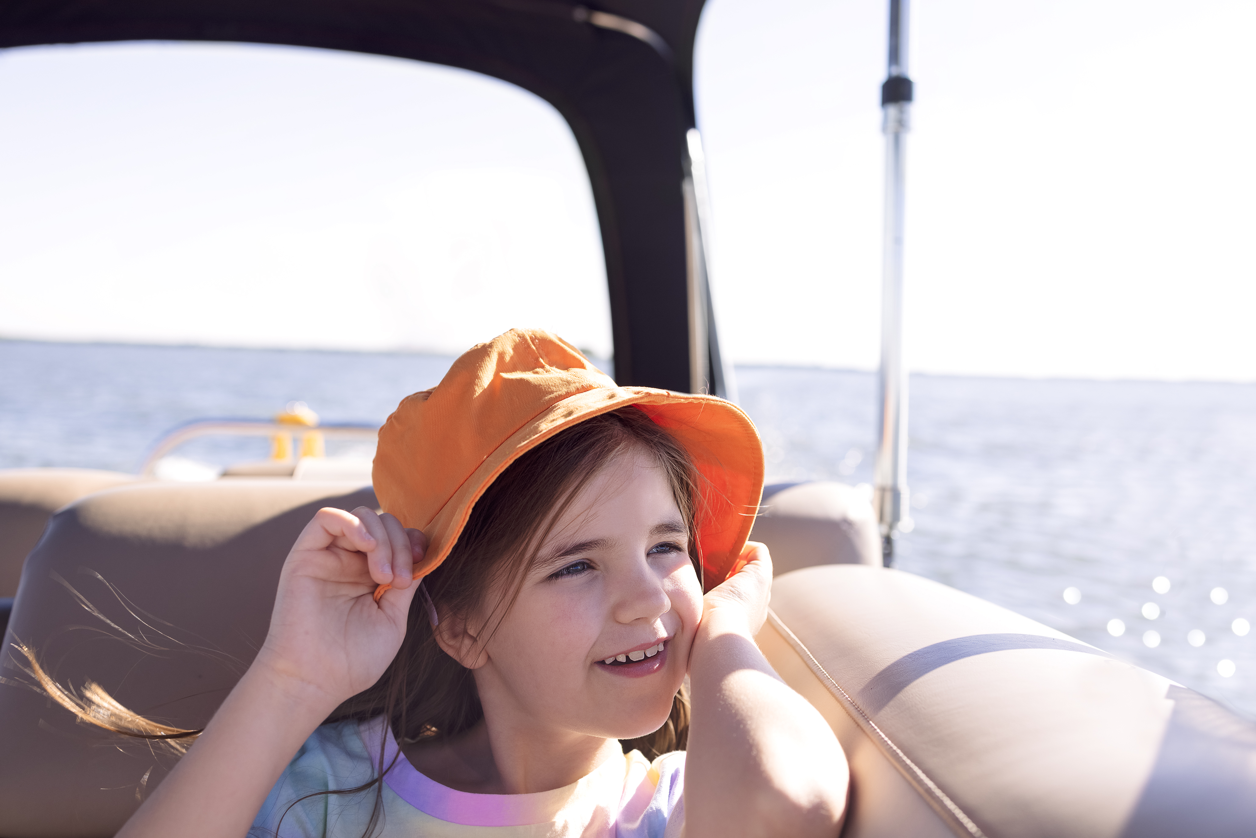 Child smiling on a pontoon boat at Lake of the Ozarks enjoying a sunny day on the water with family